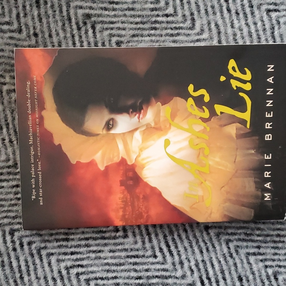 2/20$ In Ashes Lie by Marie Brennan – Paperback Fantasy Novel